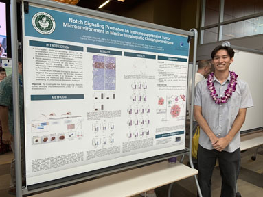 Jonathan Haynes standing next to his poster presentation